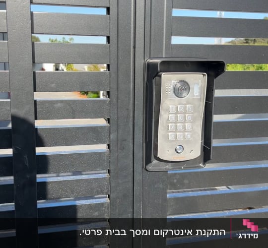 אינטרקום עם מצלמה ומקשים על שער מתכת אפור